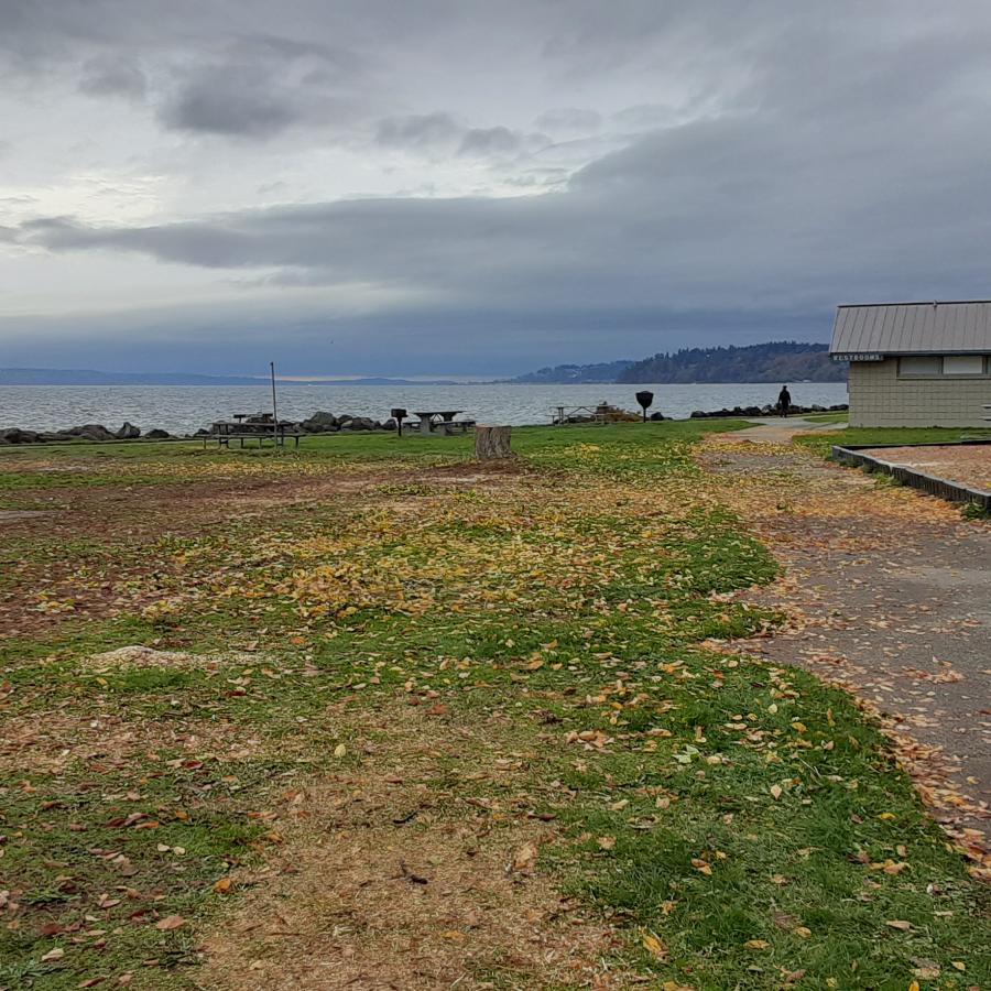 Field and playground, clouds over gray ocean.