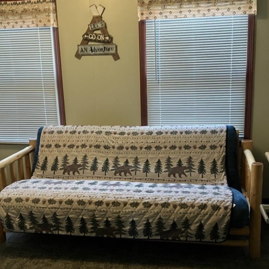 country fashion quilt covering a country style futon in front of windows