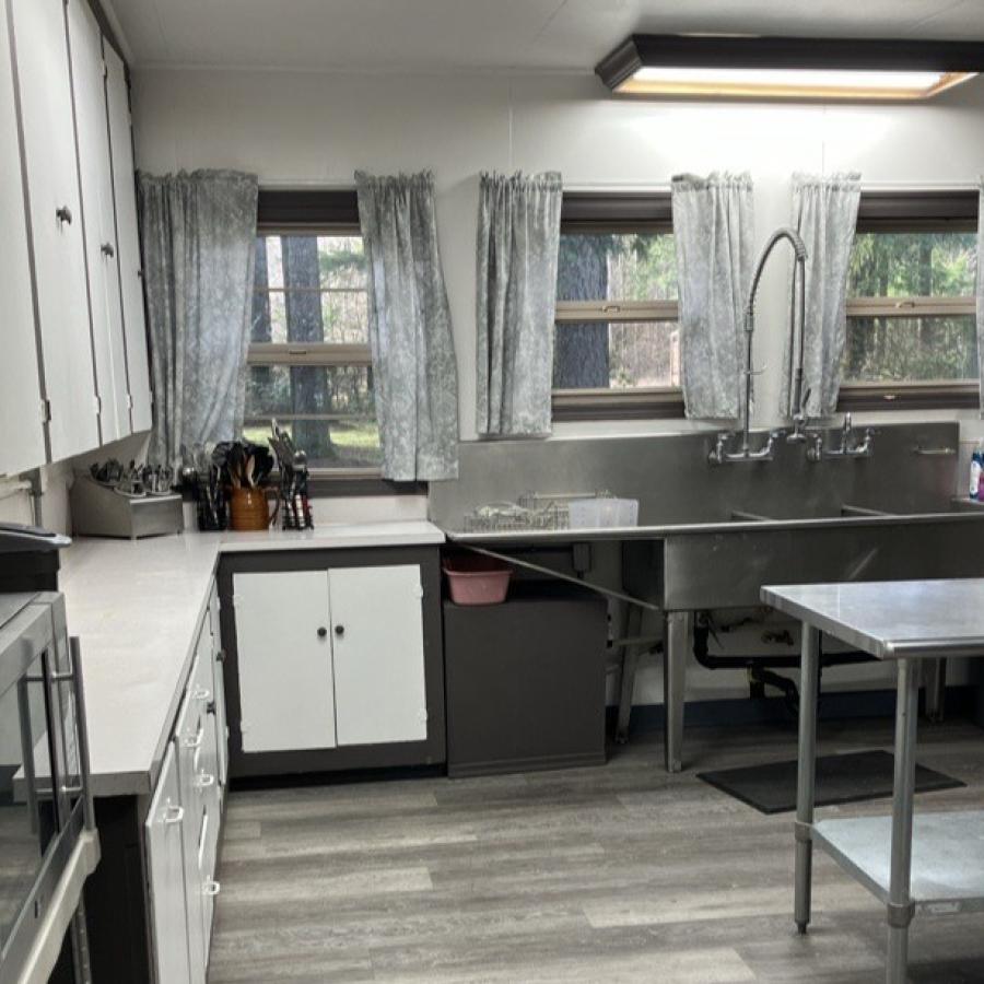 kitchen windows with large industrial stainless-steel sink and counters underneath