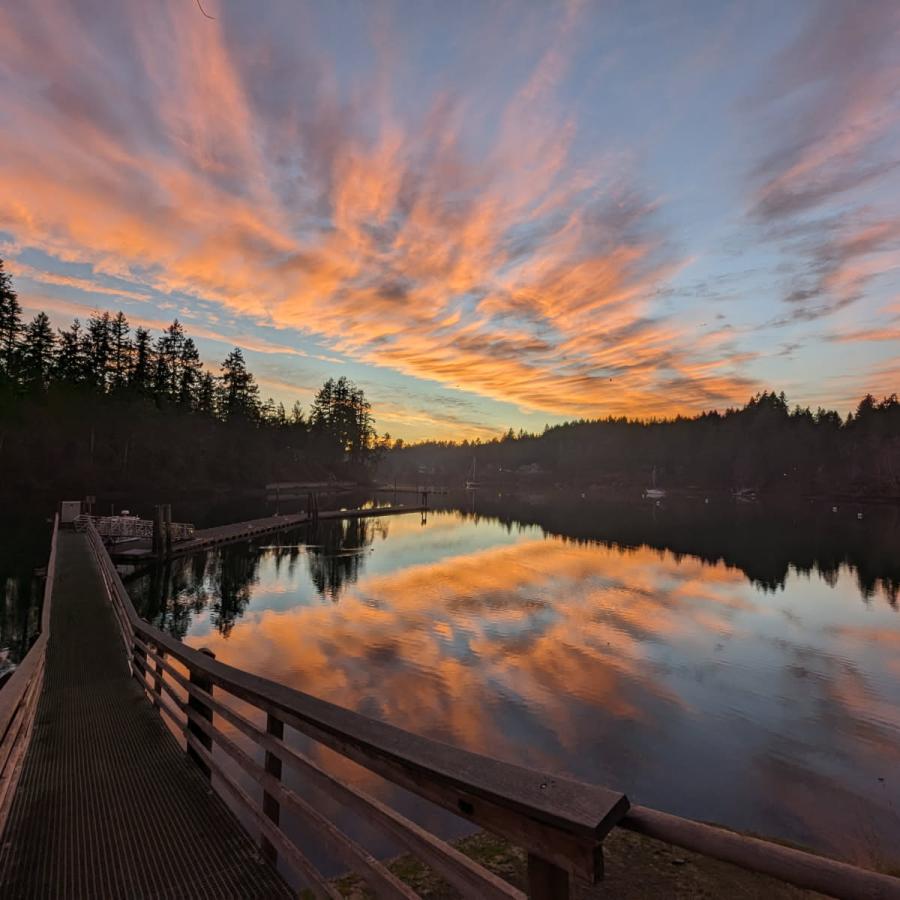 Jarrell Cove sunset with vibrant orange and purple sky reflected on the water