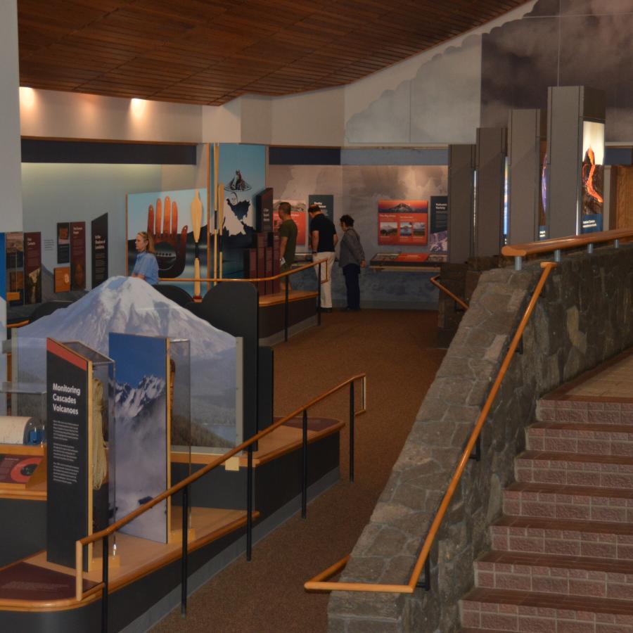 stairs leading down to exhibits along wall - exhibits displayed openly, colorful, with educational information