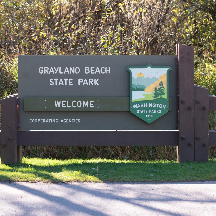 Welcome sign to Grayland Beach State Park with Image of State Parks Shield.