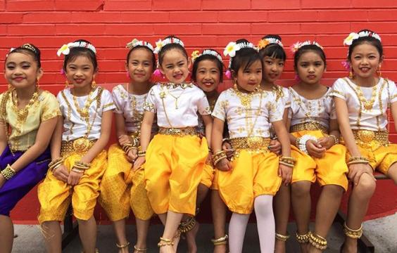 Children at a folk and traditional arts event posing together after dancing