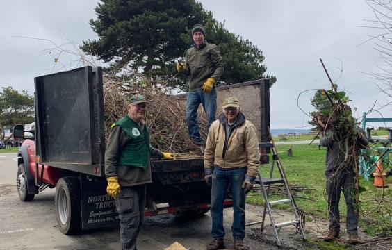 Group photo of volunteers loading debris in a truck at Fort Worden