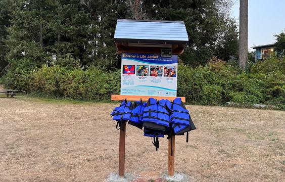 A life jacket loaner stand near a water access point